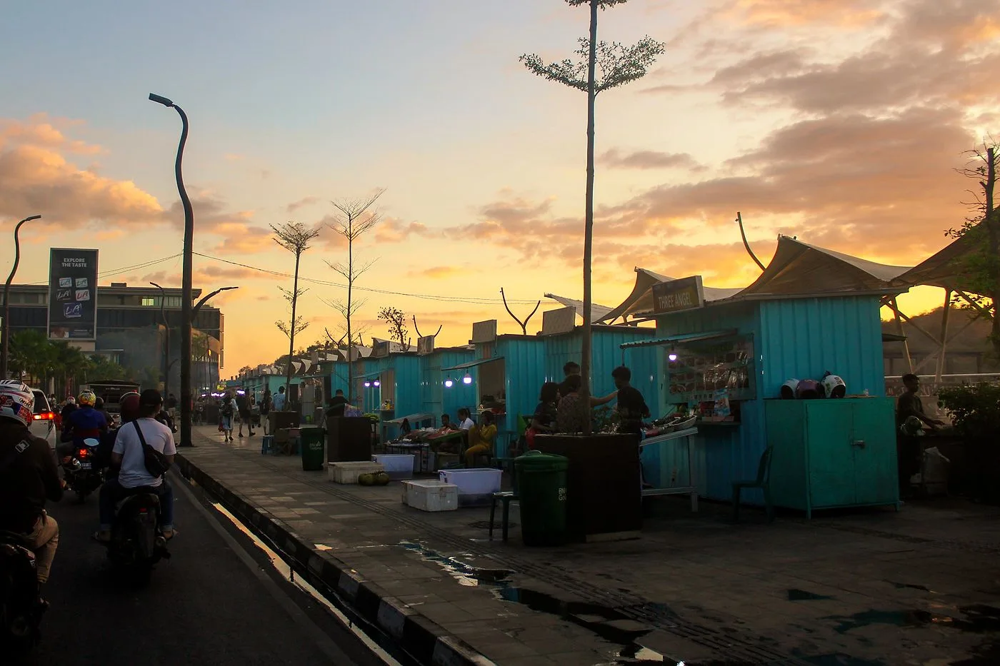 Seafood stalls and grills lining the waterfront road at Kampung Ujung market in Labuan Bajo, Flores, at sunset